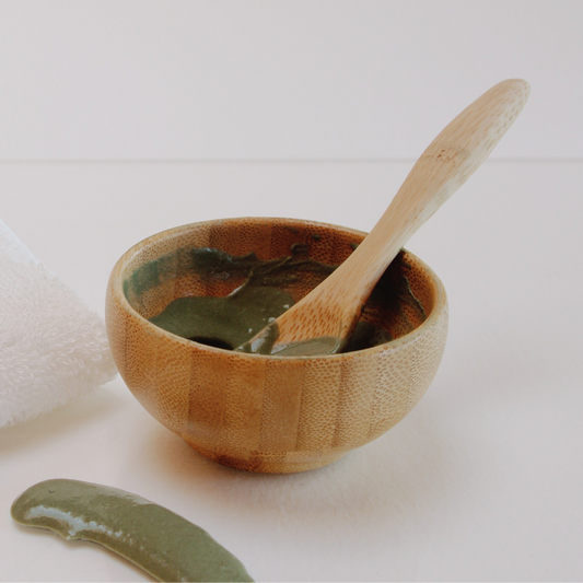 Mini bamboo bowl and spoon with green clay mixed in bowl