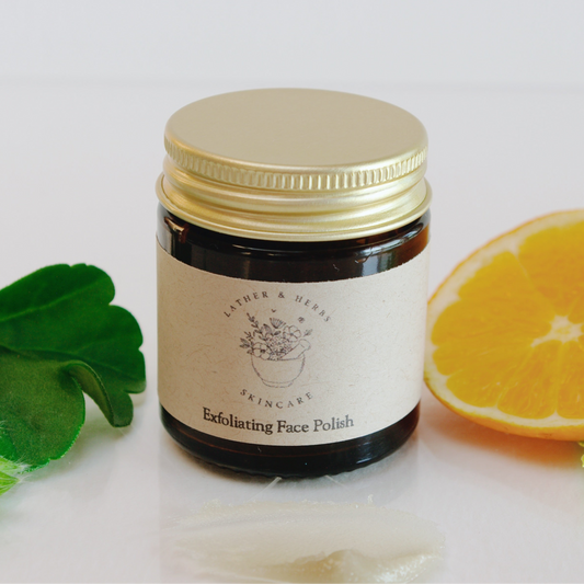 Amber glass jar with polish and a slice of orange and a geranium leaf