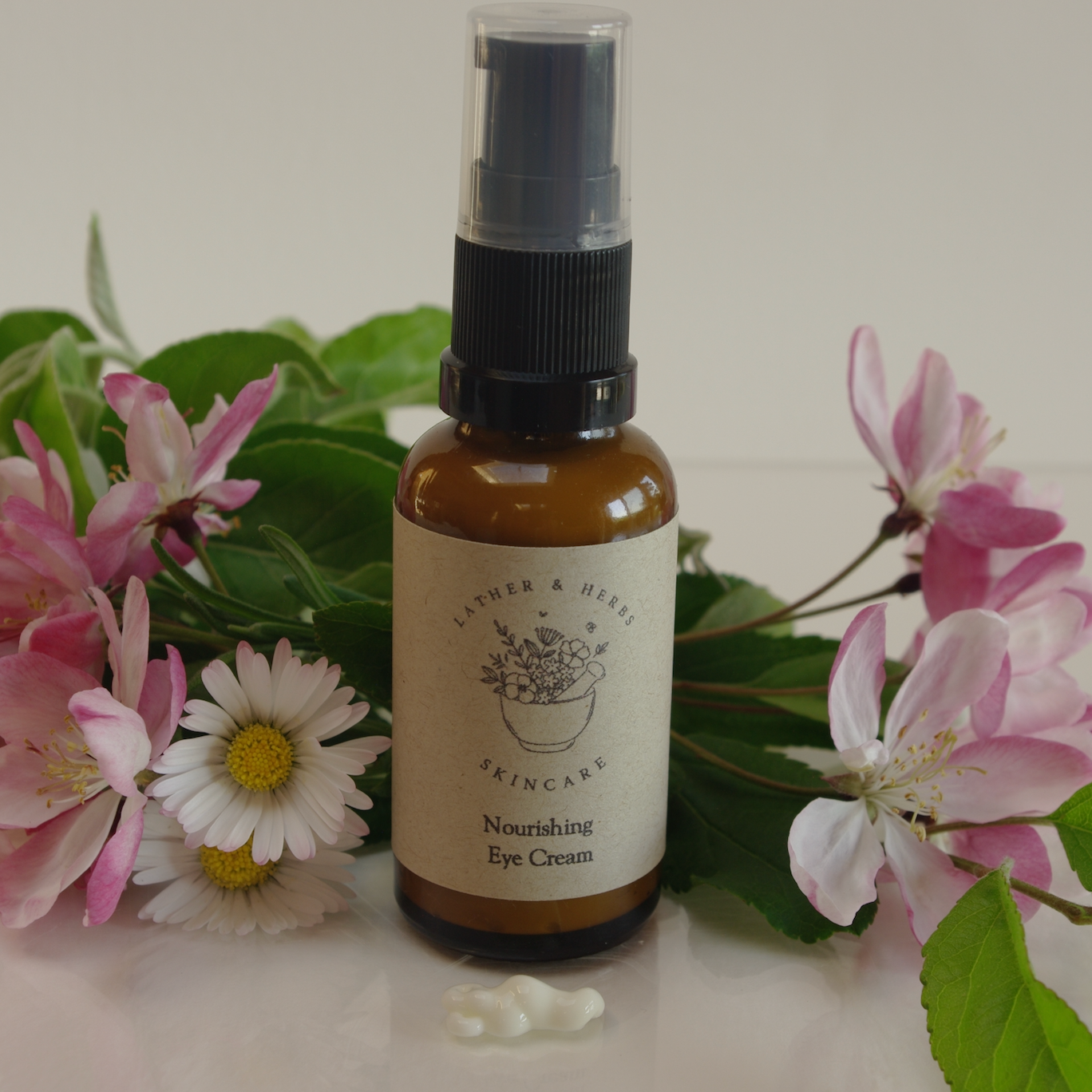 Hydrating eye cream with frankincense and orange essential oils bottles with flower blossom