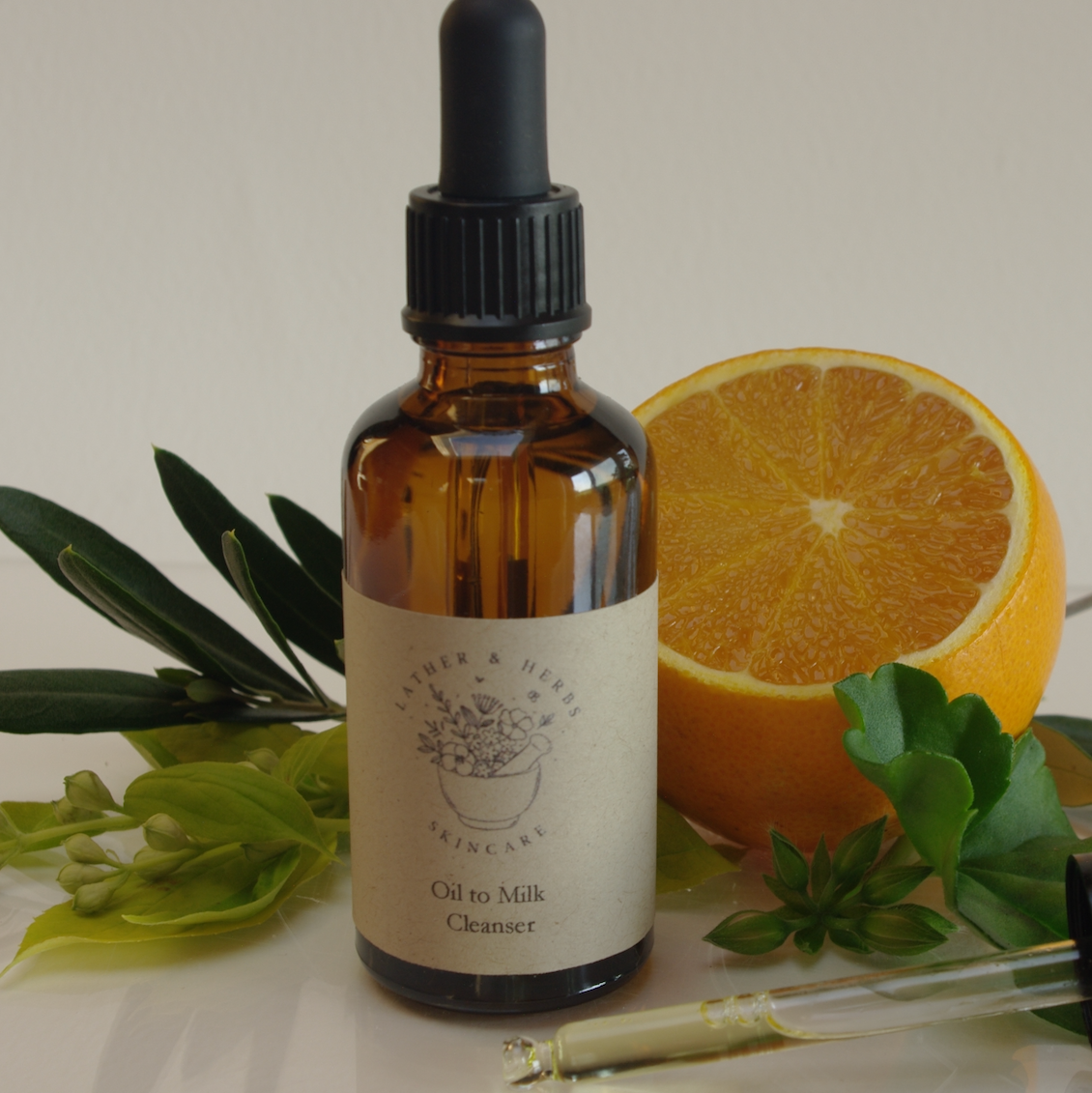OIl to Milk Cleansesr with orange blossom and geranium leaf and bud.