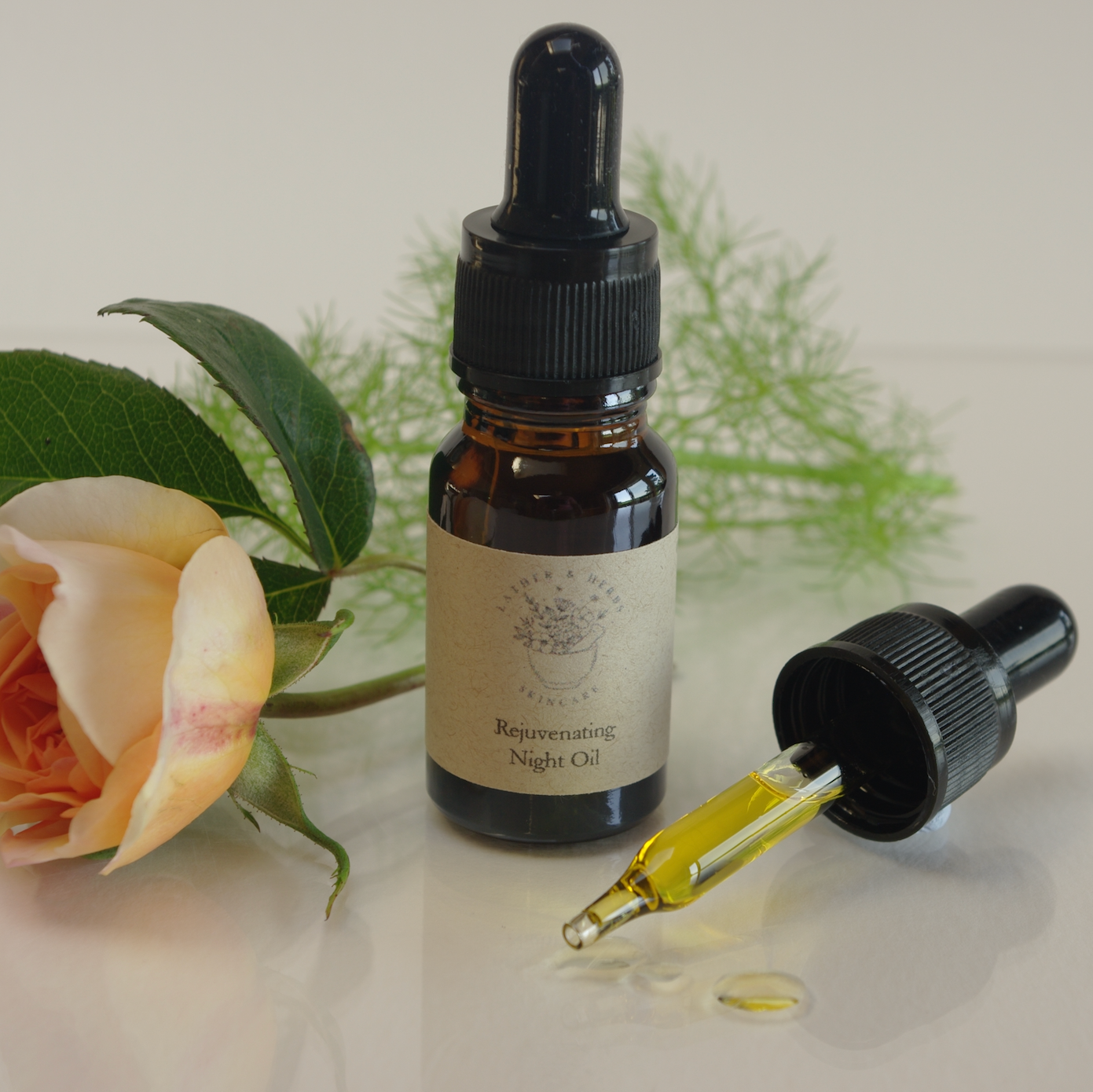 Rejuvenating night oil amber glass bottle with pipette and greenery