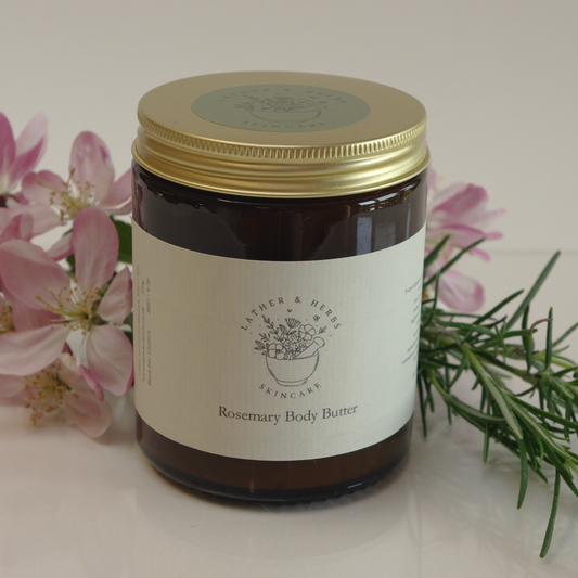 Body Butter with Rosemary and flowers in an amber jar with gold lid
