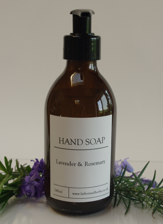 Amber bottle with black plastic pump with herb greenery 