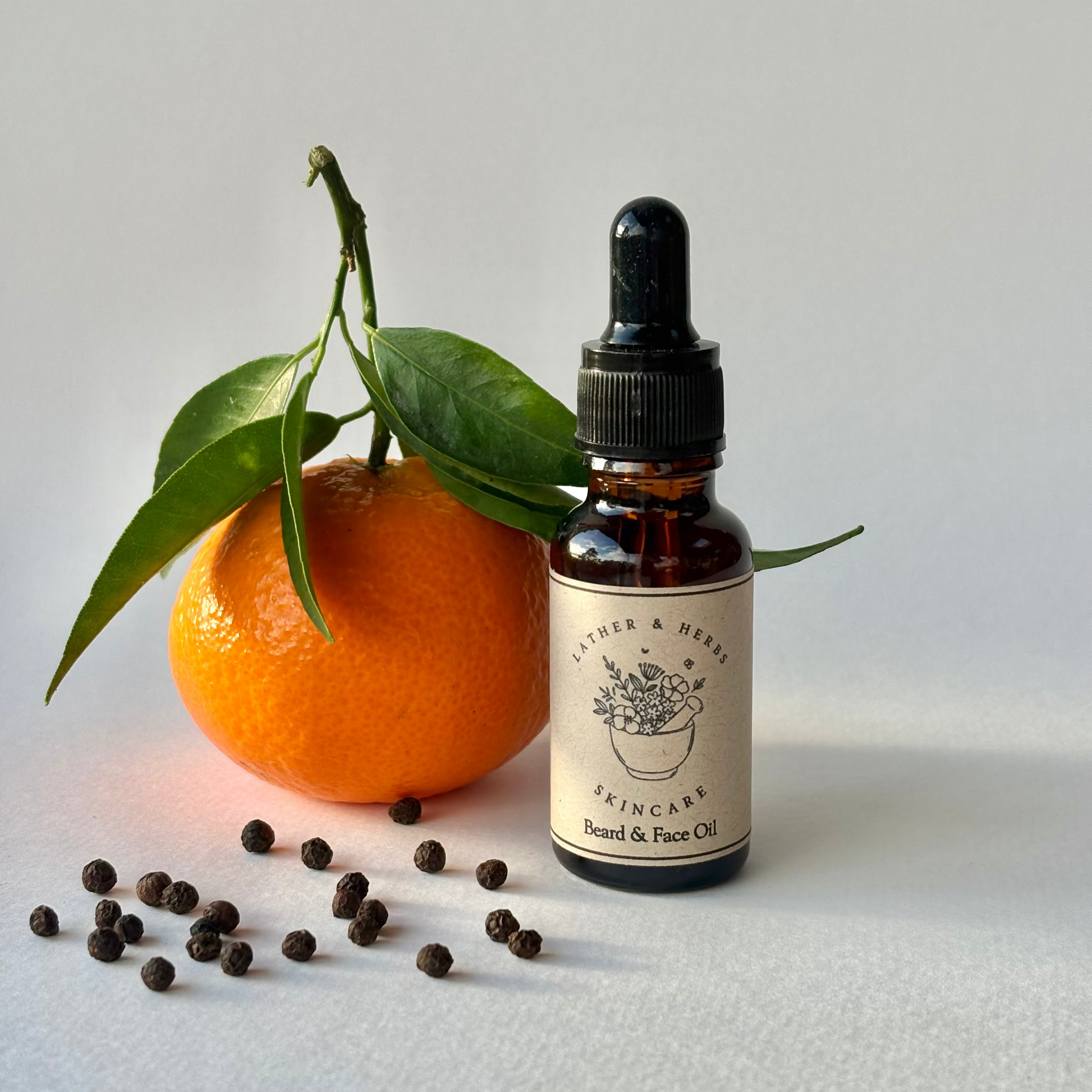 Mandarin, Black Pepper and May Chang Face and Beard Oil bottle with a mandarin and peppercorns.