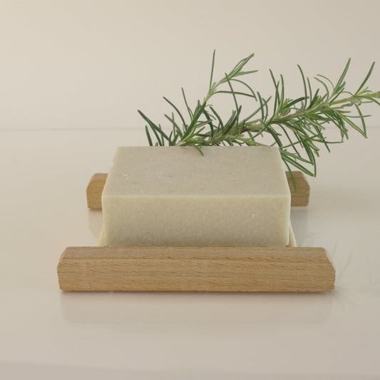 rosemary salt soap with rosemary leaves and on a bamboo soap rack