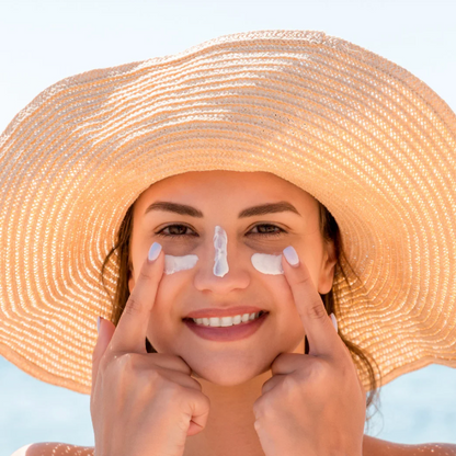 lady with sunhat an suncream on her face