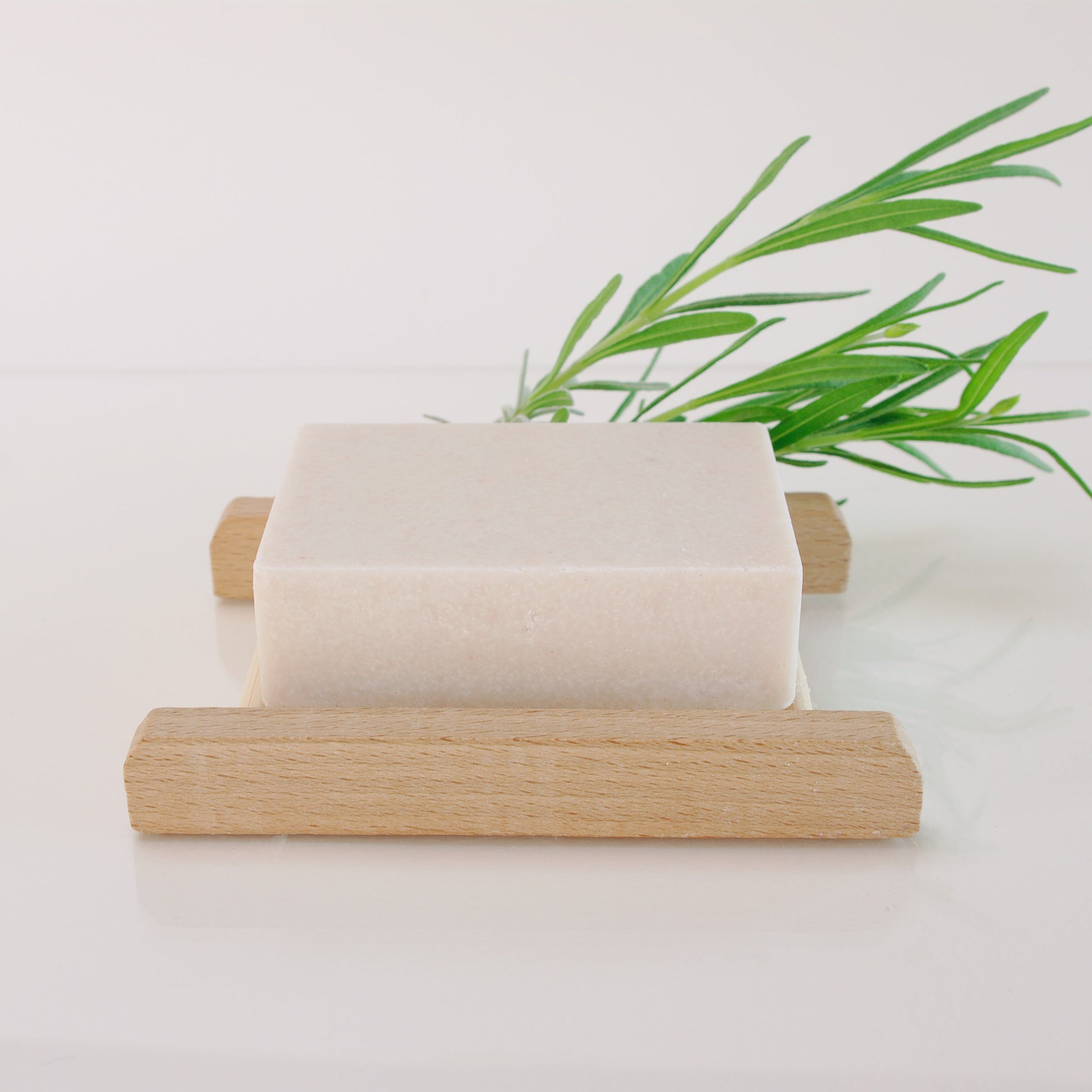 lavender salt soap on a wooden soap rack with a lavender twig