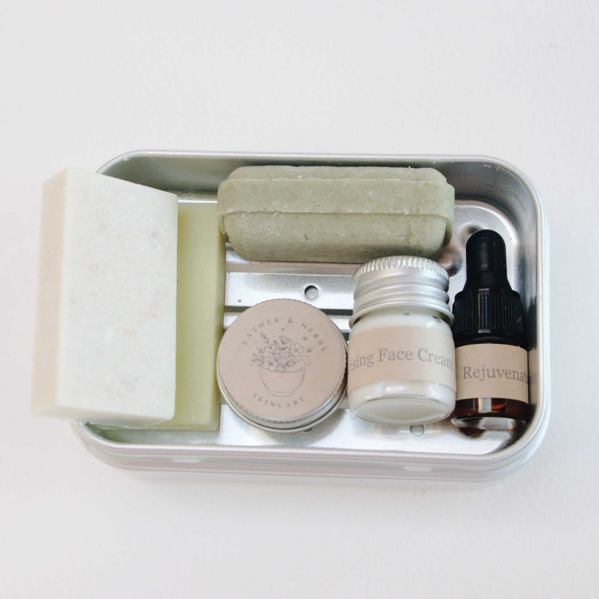 Set of skincare products in a small metal container on a white background